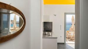 a mirror on a wall next to a kitchen with the ocean at MIKRES CYCLADES DONOUSSA in Donoussa