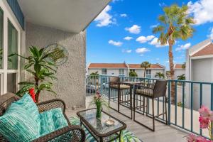a patio with chairs and tables on a balcony at Madeira Beach Yacht Club 357H in St Pete Beach