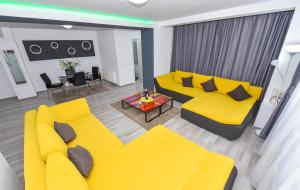 a living room with a yellow couch and a table at Bucharest Accommodation Apartments in Bucharest