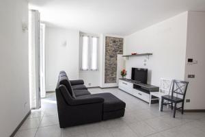 - un salon avec un canapé, une chaise et une télévision dans l'établissement APPARTAMENTO PERSEO, à Lezzeno