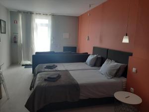 Cette chambre comprend 2 lits et une fenêtre. dans l'établissement Quartos Do Seixe - Laranja, à Odeceixe