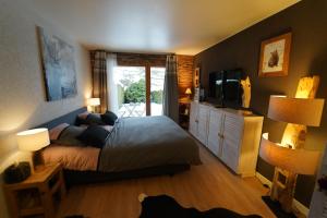a bedroom with a bed and a television and lamps at Superbe studio avec parking privé in Crans-Montana
