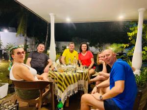 a group of people sitting around a table at White Villa Airport Transit Hotel in Katunayaka