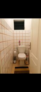 a bathroom with a toilet in a tiled room at Maison de vacances créole à Rivière Salée in Rivière-Salée