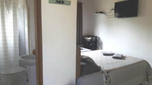 a bathroom with a bed and a sink and a toilet at Chalé das Alamandas in Socorro