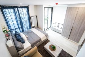 una camera con un grande letto in una stanza con finestre di I'm Chinatown Residence a Bangkok