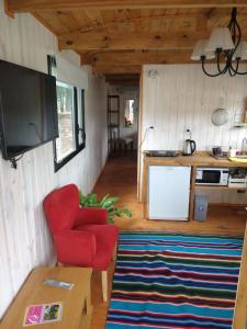 サン・ヴィセンテにあるHotel y Casa de Campo Oasis Campero - Ezeiza Aeropuerto -San Vicenteの赤い椅子とキッチンのあるリビングルーム