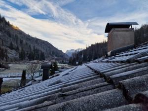 a snow covered roof of a house with a mountain at Appartamento Latemar Predazzo in Predazzo