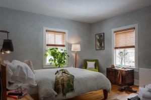 een slaapkamer met een groot bed en twee ramen bij Howland House in Mount Tremper