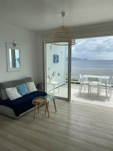 a living room with a couch and a view of the ocean at FACE À LA MER in Schœlcher