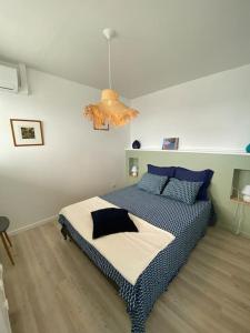 a bedroom with a large bed with blue pillows at FACE À LA MER in Schœlcher