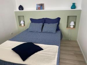 una camera da letto con un letto blu e bianco con cuscini blu di FACE À LA MER a Schœlcher