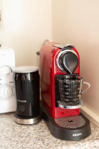 einem roten Toaster auf einer Theke neben einer Kaffeemaschine in der Unterkunft Alana Care Bed & Breakfast in Tonden
