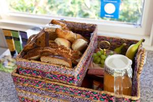 Alana Care Bed & Breakfast في Tonden: سلة مليئة بالخبز والأطعمة الأخرى على الطاولة