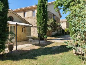 a courtyard of a building with a table in the yard at Gite Le Figuier - La Roseraie du Val'ensoleillé in Valensole