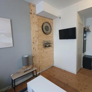 een kamer met een bed en een klok aan een muur bij Villa Etiennette 1 in Le Crotoy
