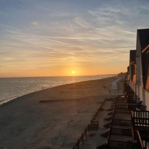 een uitzicht op het strand bij zonsondergang bij Villa Etiennette 1 in Le Crotoy