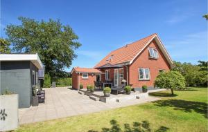 een stenen huis met een patio in een tuin bij 4 Bedroom Awesome Home In Sams in Ballen