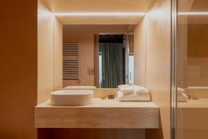 un bagno con lavandino e specchio di Design apartment with private pool in Campo dei Fiori a Roma
