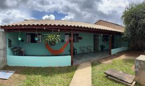 ein grünes Haus mit einer roten Hängematte davor in der Unterkunft Casa Esmeralda in Alto Paraíso de Goiás