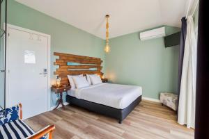 sypialnia z łóżkiem i drewnianym zagłówkiem w obiekcie Marina Blue - Apartments & Suites w mieście Setúbal