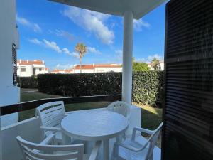 a white table and chairs on a balcony at Apartamentos Mar a mar in Cala en Forcat