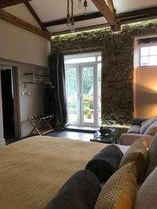 un soggiorno con un grande letto e un muro in pietra di Luxury Barn Conversion at Rudding a Harrogate