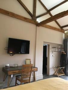 Camera con scrivania e TV a parete. di Luxury Barn Conversion at Rudding a Harrogate