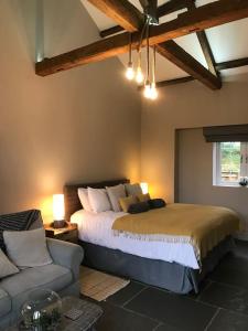 um quarto com uma cama grande e um sofá em Luxury Barn Conversion at Rudding em Harrogate