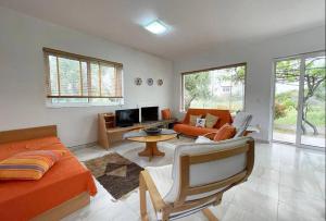a living room with an orange bed and a couch at Gennadi Big House in Gennadi