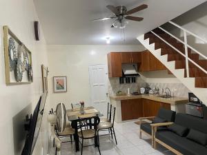 a living room with a table and a kitchen with a stair at Townhouse Apartment near SM City Lucena in Lucena