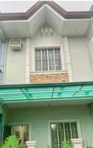 a house with two windows and a balcony at Townhouse Apartment near SM City Lucena in Lucena