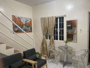 sala de estar con mesa, sillas y ventana en Townhouse Apartment near SM City Lucena, en Lucena
