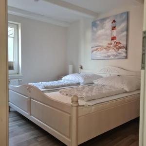a bedroom with a bed with a lighthouse painting on the wall at Fewo "Marienleuchte" in Bannesdorf auf Fehmarn in Fehmarn