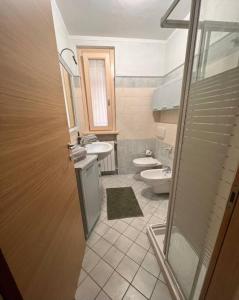 a bathroom with a toilet and a sink and a shower at Csendes és nyugodt hely medencével. in Parzanica +26 photos