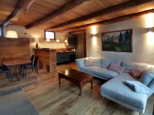 a living room with a blue couch and a table at Ca' Maira Casa di montagna in Val Maira con vista in Roccabruna