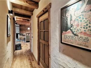 a hallway with a door and a poster on the wall at Ca' Maira Casa di montagna in Val Maira con vista in Roccabruna