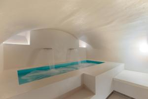 una piscina al centro di una stanza bianca con acqua di Design apartment with private pool in Campo dei Fiori a Roma