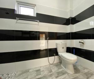 baño con pared de rayas en blanco y negro en Villa Sun Rising, en Talpe