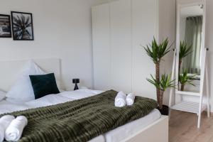 ein weißes Schlafzimmer mit einem Bett mit einer grünen Decke in der Unterkunft Modern 3Room Apartment Free Wifi Netflix and free Parking in Hamm