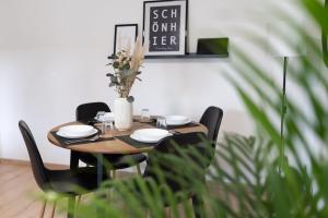 a wooden table with chairs and a vase with flowers at Apart63-Modern-3Room I Smart TV I Free Parking I Free WiFi in Hamm