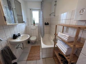 ein Badezimmer mit einem Waschbecken, einer Badewanne und einem WC in der Unterkunft Modern 3Room Apartment Free Wifi Netflix and free Parking in Hamm