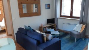 sala de estar con sofá azul y silla en Maison à Tour Briançon en Briançon