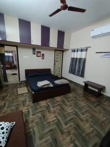 a bedroom with a bed and a ceiling fan at Doctor's Homestay in Tiruvannāmalai