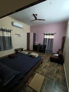 um quarto com uma cama e um sofá em Doctor's Homestay em Tiruvannamalai