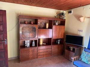 una sala de estar con un gran centro de entretenimiento de madera en Los Pachis, en La Paloma