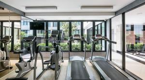 un gimnasio con cintas de correr y equipo cardiovascular en un edificio en Notthing Hill Charoenkrung93 Condominium, en Godown