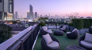 a rooftop patio with chairs and a city skyline at Notthing Hill Charoenkrung93 Condominium in Godown