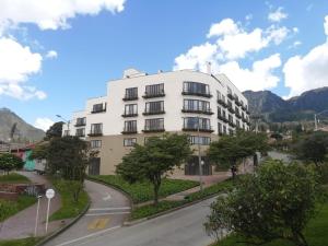 a white building with a road in front of it at Gestión Hotelera - Morph Candelaria in Bogotá