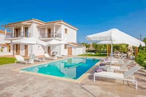 una villa con piscina y sombrillas en Villa Rodakinia, en Ambelókipoi